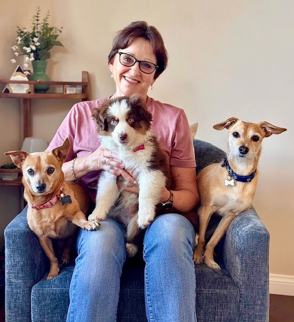 Janine Fox smiling with her three dogs